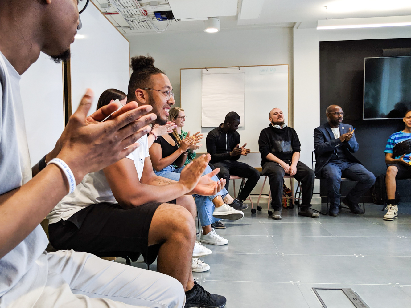 Switchback Trainees and staff applauding together during a group session