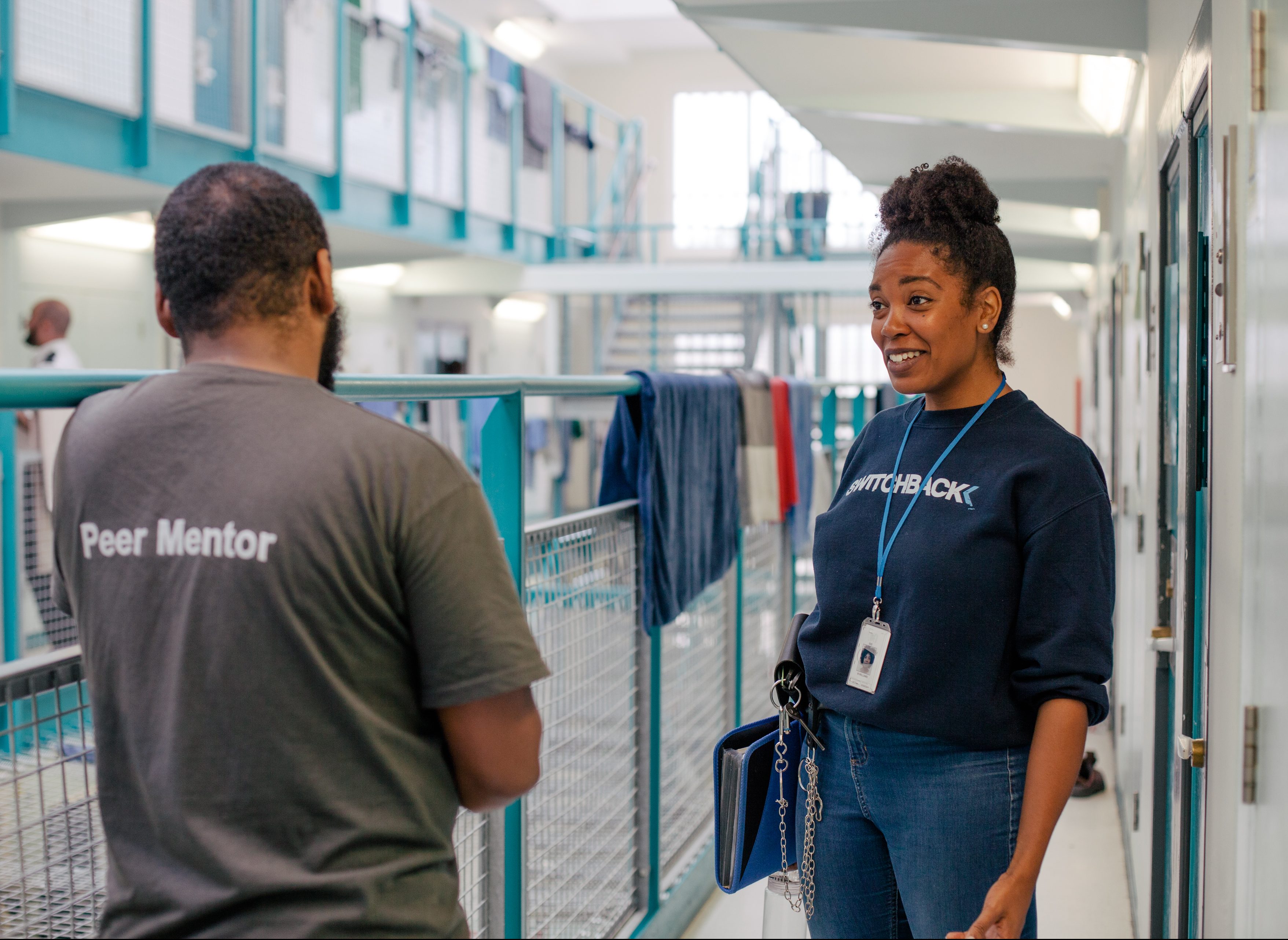A Switchback peer mentor talking with a Switchback caseworker on a landing inside HMP Isis in London